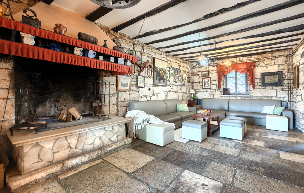 Rustic living room with a large stone fireplace and beamed ceiling